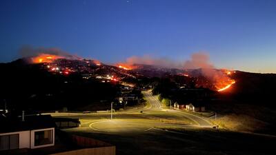 随着太阳落山,基督城港口山的大火仍在继续燃烧。