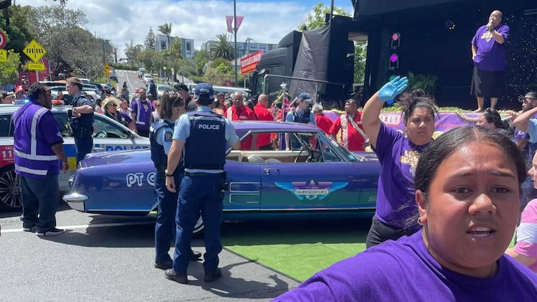 A Burger Fuel-branded car crashes into a brass band at Avondale's Santa Parade.