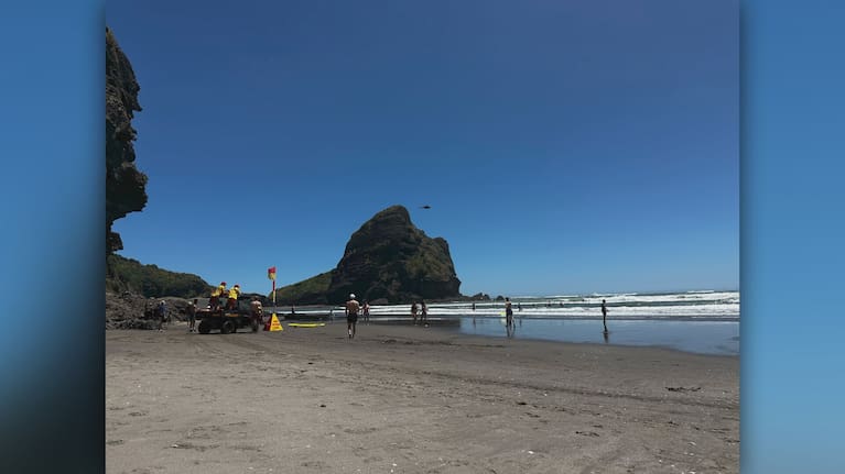 A helicopter is seen flying over Piha Beach Thursday.