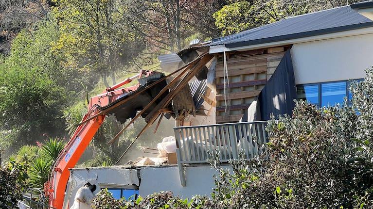 A house damaged by a slip during last year's storm is now being destroyed.