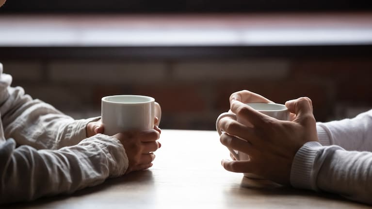 A man and woman talking over cups of coffee (file image).