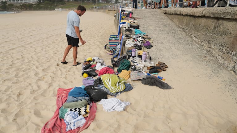 A man looks at belongings stacked up following the morning after the horrific shooting at Sydney's Bondi Beach.
