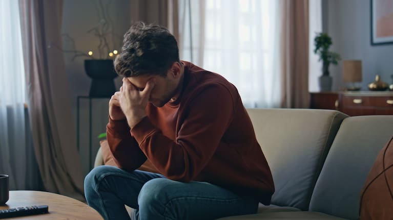 A man with a headache holds his head.