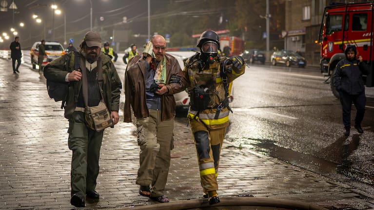 A rescuer helps an injured man after a Russian strike on a residential building in Kyiv, Ukraine