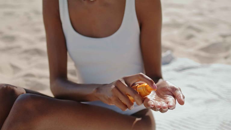 A woman applying sunscreen at the beach (file image).