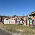 About 70 residents gather at the Pines bus stop to show their opposition to speed-limit reversals on SH35 in Gisborne. Veronika Lambert, kneeling, bottom left, organised a petition in 2019 to lower the limit on the road.