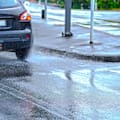 After a short concentrated rain, cars are seen splashing water driving through a pedestrian crossing in Grafton to State Highway 1 in Auckland.