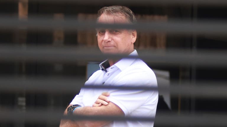 Brazil's former President Jair Bolsonaro stands at the entrance of his home where he is under house arrest in Brasilia