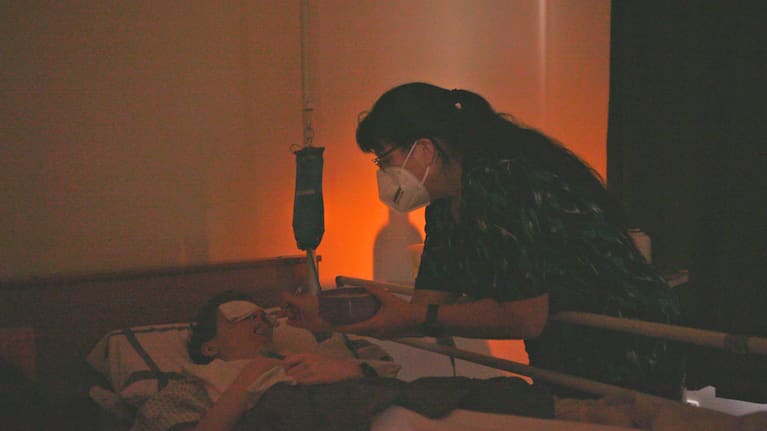 Glenys Rumsey spoon feeding her daughter Tammy in darkness. Photo/Zoe Madden-Smith.