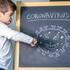 Child punching a blackboard with a cartoon drawing of the coronavirus on it.