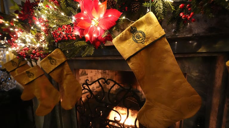 Christmas stockings created by members of the King's Foundation Sewing Bee group, which have been made using curtains repurposed from the Sandringham Estate in Norfolk, are hung from the fireplace in the Yellow drawing room at Dumfries House.