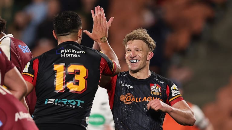 Chiefs first-five Damian McKenzie celebrates Anton Lienert-Brown's try against the Reds.