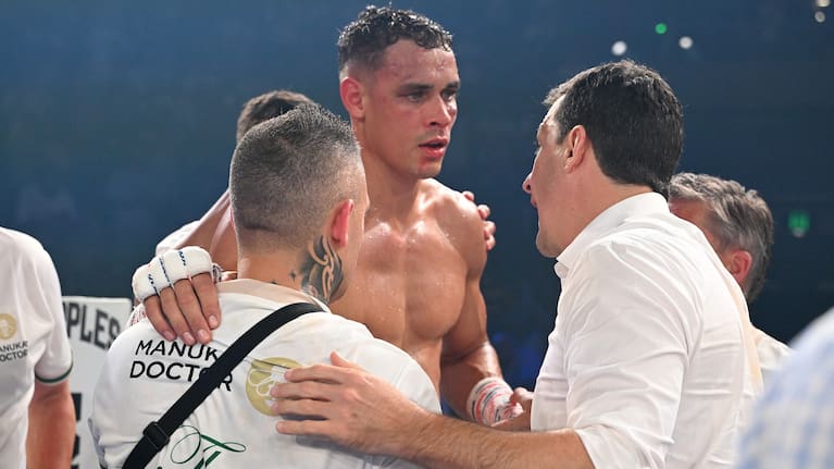A dazed David Nyika is supported by his team after being knocked out by Jai Opetaia in their world cruiserweight fight.