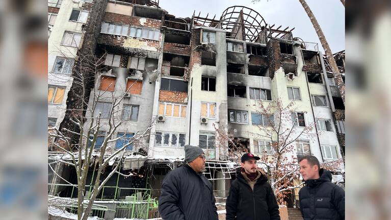 Defence Minister Peeni Henare listens among the rubble of a building destroyed in the Russian invasion of Ukraine.