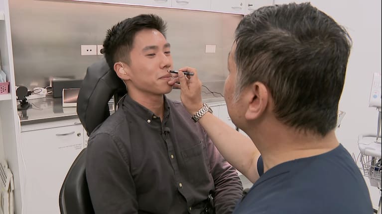 Dr Garsing Wong performs a consultation on Breakfast reporter Cameron Joe.