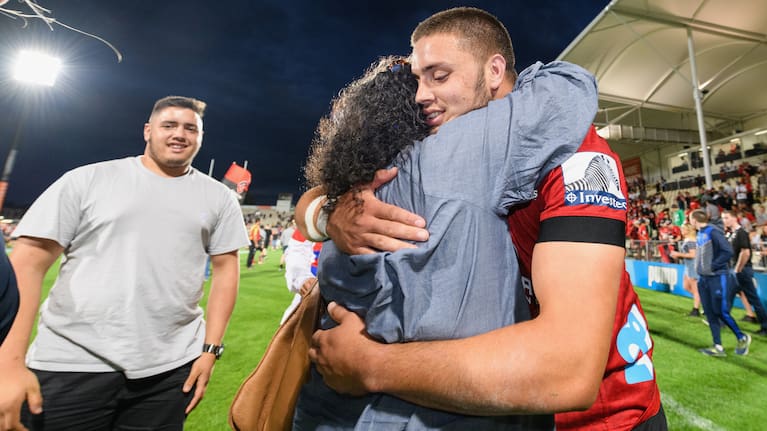Ethan Roots is congratulated after making his Crusaders debut in 2020.