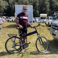 Ian Walsh at the finish line with the foldable bike he borrowed to complete the 55km cycling stage of the Coast to Coast.