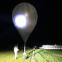 In this undated photo released by the State Border Guard Service, an officer inspects a balloon used to carry cigarettes into Lithuania