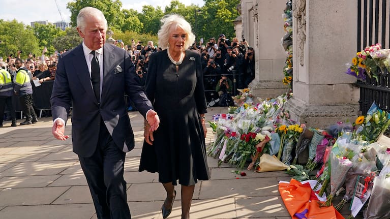 King Charles III, and Camilla the Queen Consort, look at floral tributes.