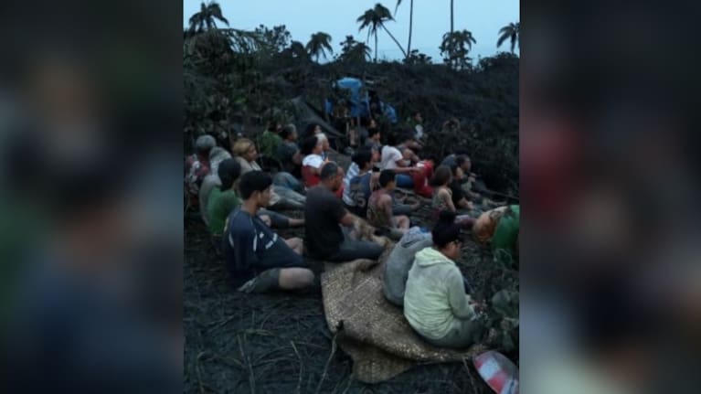 Mango Island residents covered in volcanic ash waiting to be evacuated.