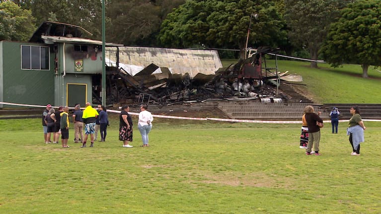 Marist Saints club members look on at the damaged building.