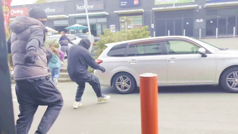 Masked and armed robbers head for a car at Dress Smart in Auckland's Onehunga