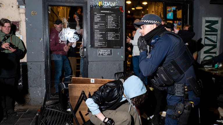 Police arrest a protester outside the damaged storefront during the anti-police protest in Melbourne in July.