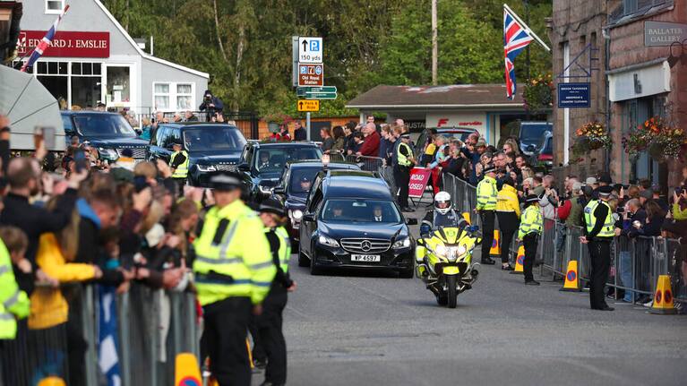 Members of the public line the streets in Ballater, Scotland, as the hearse carrying the coffin of Queen Elizabeth II passes through
