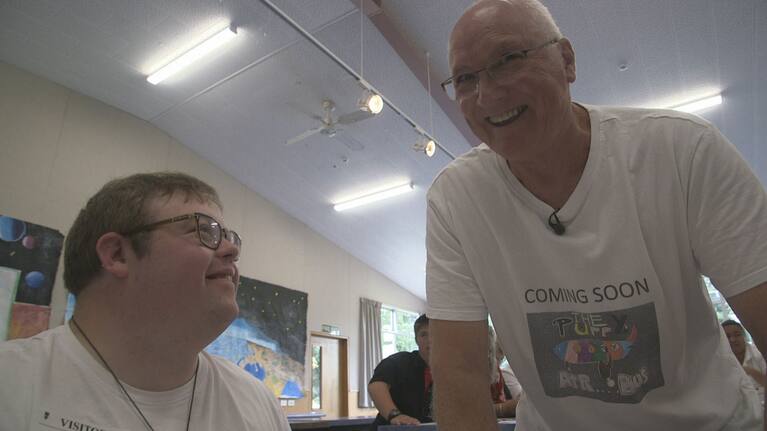 Mike Deavoll speaks to one of his students