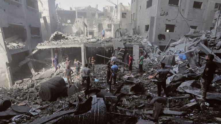 Palestinians inspect the rubble of a building, destroyed by an Israeli army strike at Al-Shati camp in Gaza City