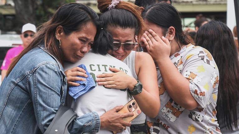 People grieve after identifying the body of a victim outside Cebu Provincial Hospital in Bogo City