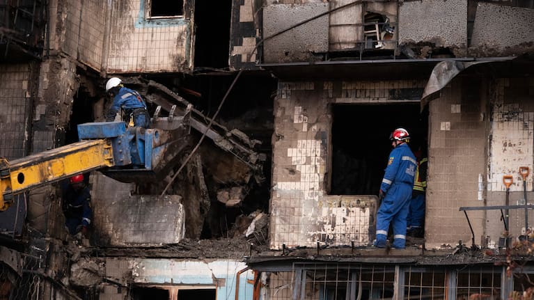 Firefighters work at a damaged apartment building following a Russian attack.