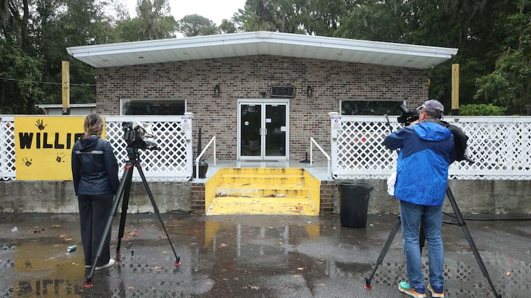 People stand outside of Willie's Bar and Grill in St Helena Island after a shooting occurred.