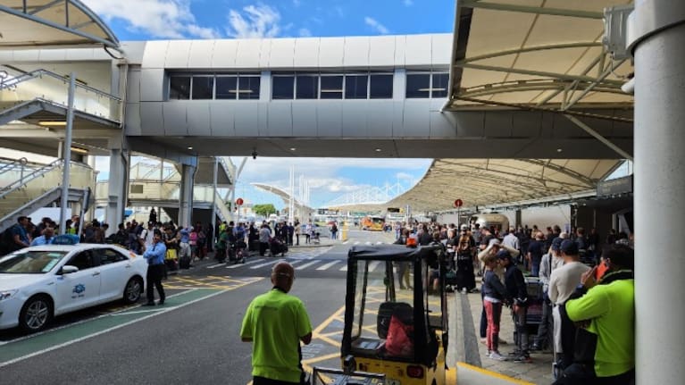 People standing outside Auckland Airport after it was evacuated this afternoon.