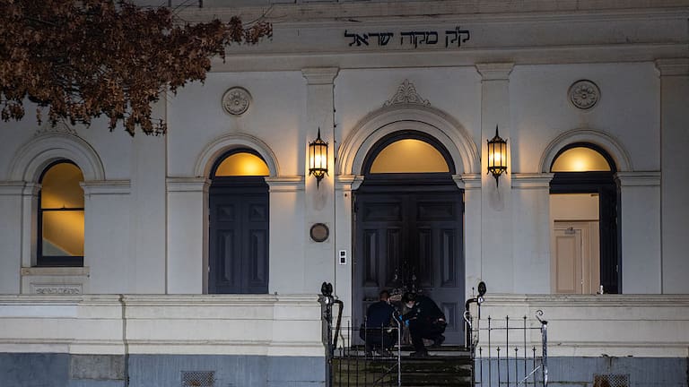 Police officers are seen collecting evidence at the scene of an arson attack at one of Melbourne's oldest synagogues.
