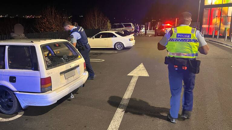 Police officers check vehicles.