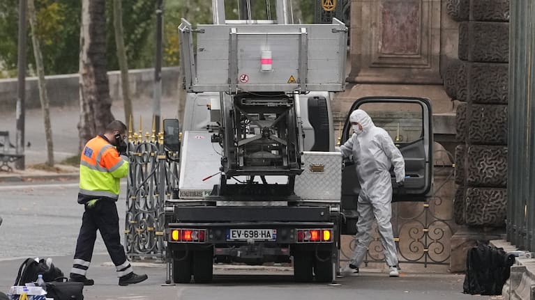 Police officers look for clues by a basket lift used by thieves Sunday, Oct. 19, 2025 at the Louvre museum in Paris