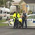 Police stand guard at the scene of a fatal shooting in Auckland's Pakuranga