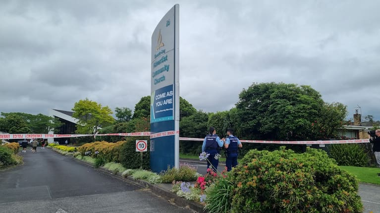 Police standing in front of the Seventh Day Adventist Community Church in Papatoetoe.