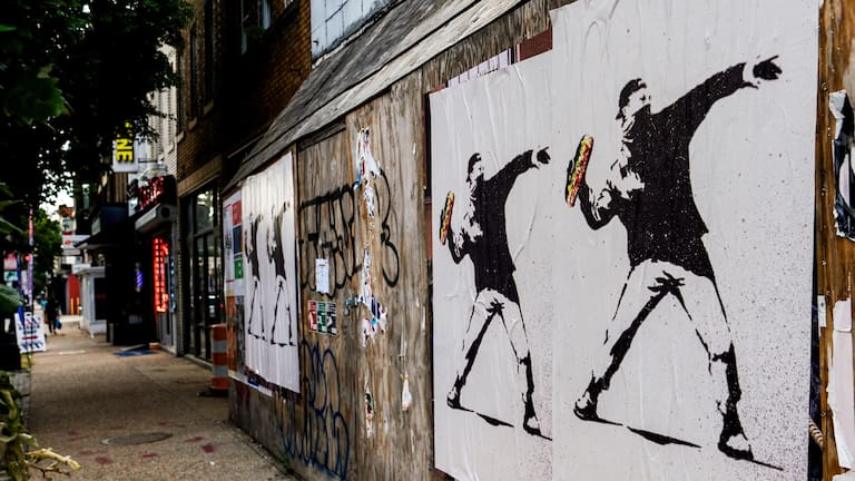 Posters of a person throwing a sandwich are pictured along H Street, August 17, 2025, in Washington.