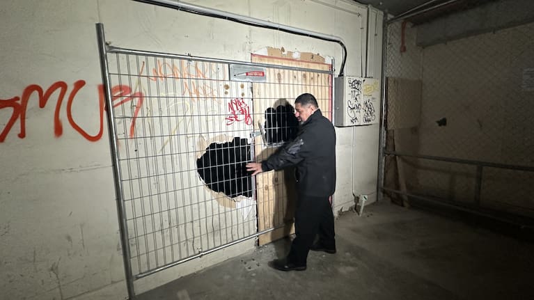 Property manager Jason Dunn shows the holes made by firefighters to gain access to the derelict building in Wellington today.
