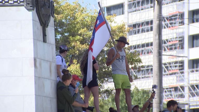 Protester standing on the Wellington Cenotaph and the anti-mandate protest in Parliament.
