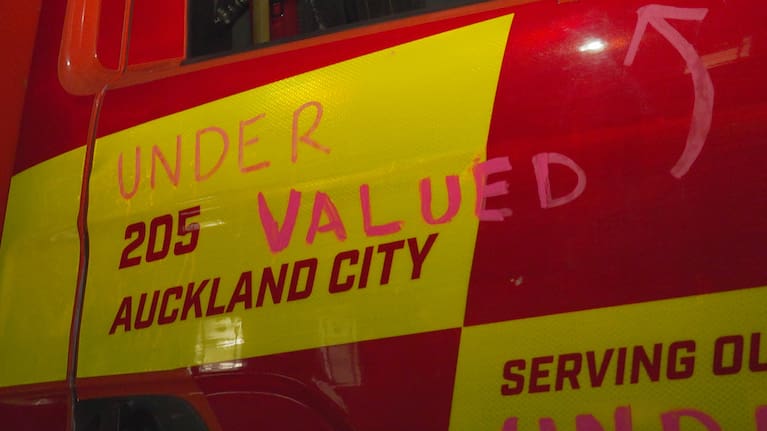Protests written on the side of a firetruck.