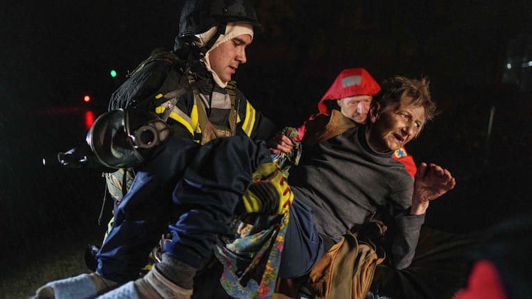 Rescuers carry an injured woman into an ambulance after a Russian strike on a residential neighborhood in Kyiv, Ukraine.