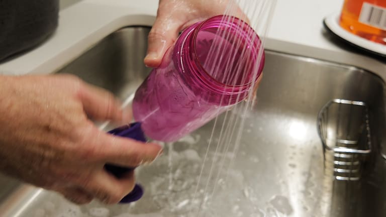 Reusable water bottle being washed.