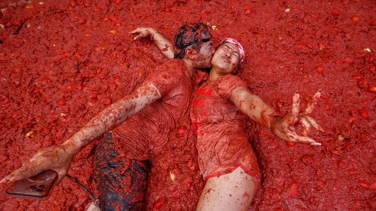 A couple kisses over a puddle of tomatoes during the annual "Tomatina" tomato fight fiesta, in the village of Bunol near Valencia, Spain.