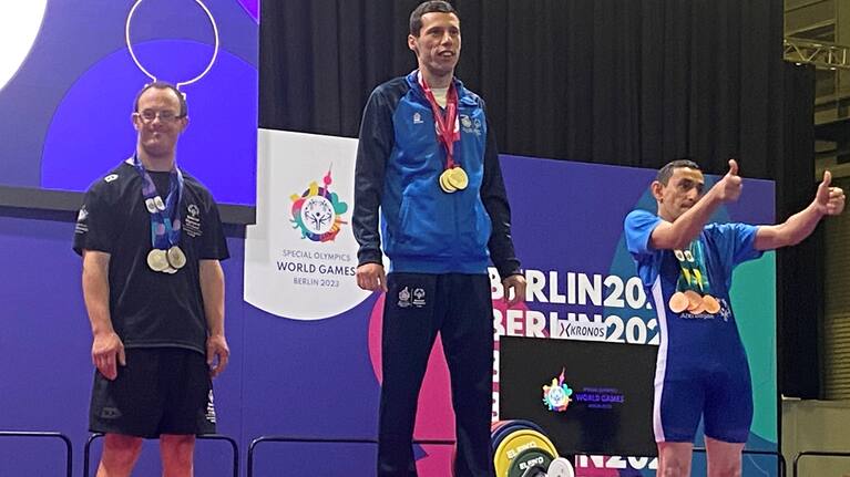 Ryan Stewart, left, stands on the podium after winning four powerlifting silver medals at the Special Olympics in Berlin.