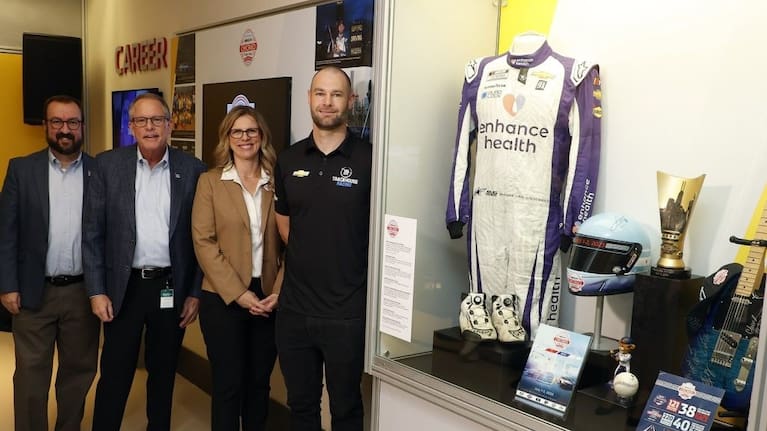 Shane van Gisbergen unveils the display alongside Chicago Street Race President Julie Giese and NASCAR Hall of Fame Executive Director Winston Kelley in Charlotte, North Carolina.