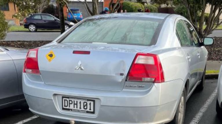 Silver Mitsubishi with kiwi sticker on back.