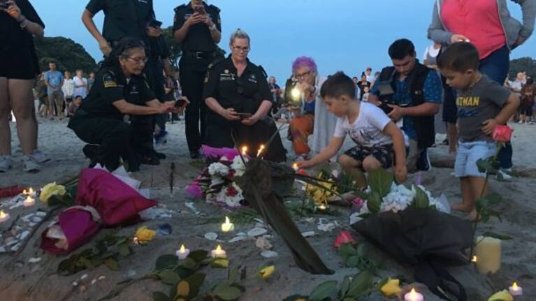 Families lay out candles and flowers in Tauranga for the victims of the Christchurch terrorist attack.